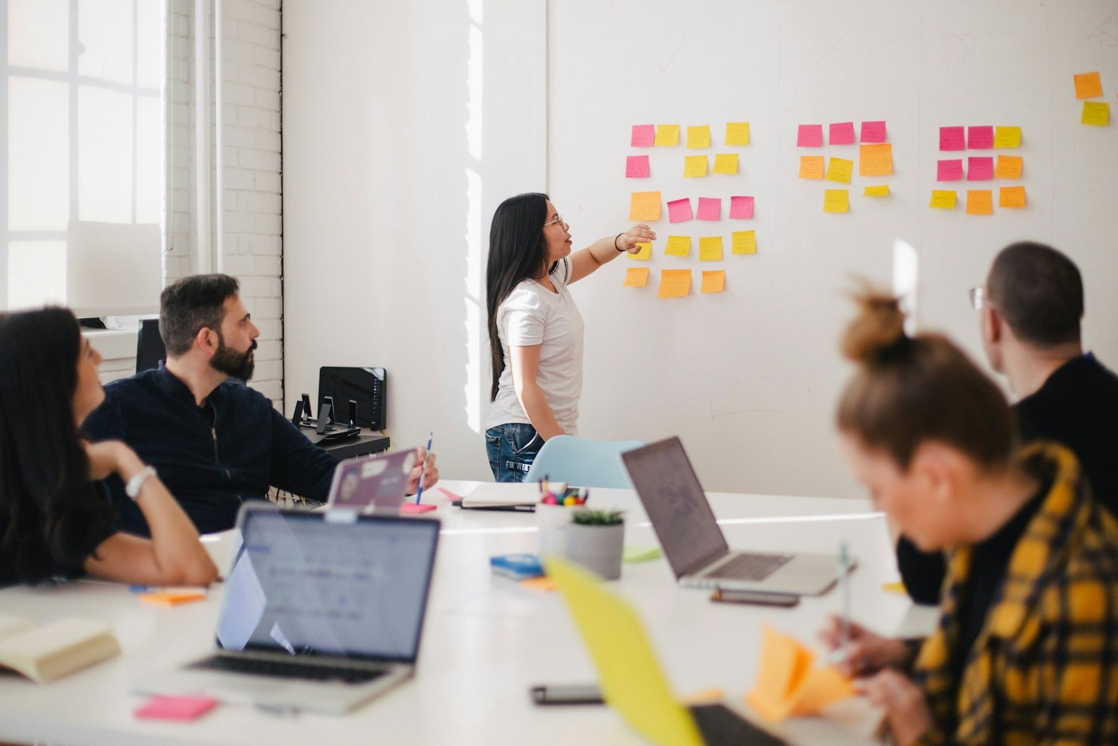 Small business team mapping an AI-assisted operating workflow on a wall